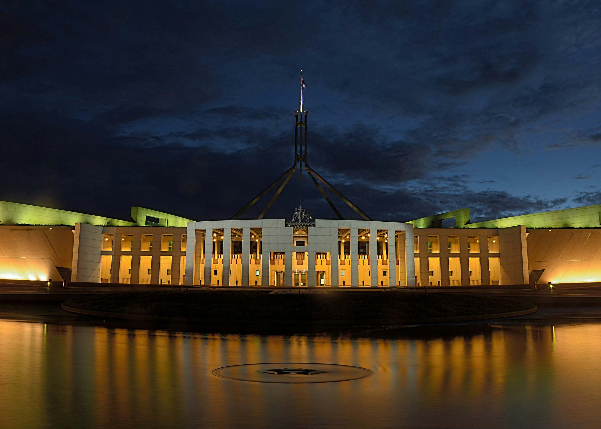 Parliament House, Canberra, lit up at dusk